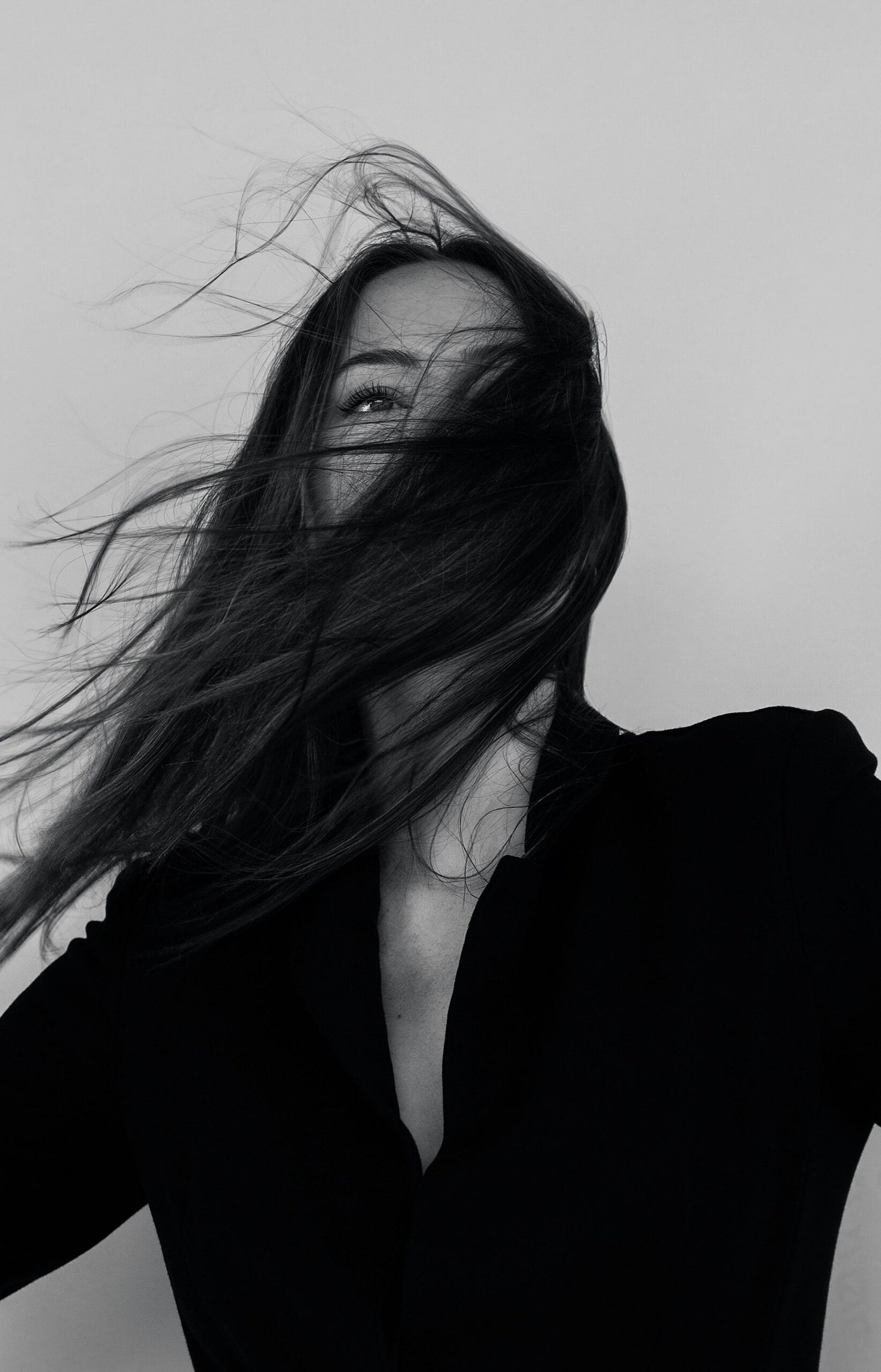 Portrait en noir et blanc d’une femme aux cheveux au vent