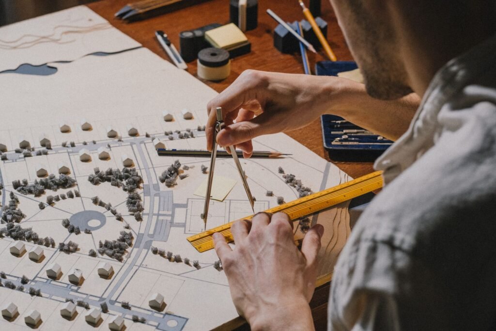 Architecte qui mesure au compas une maquette de quartier résidentiel